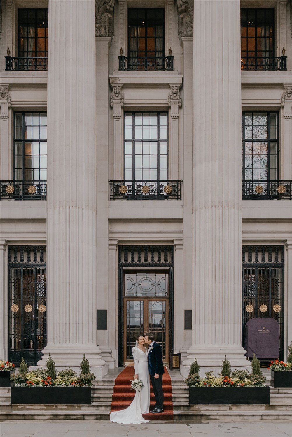bride and groom couple portraits outside the four seasons hotel near tower bridge at winter wedding in london