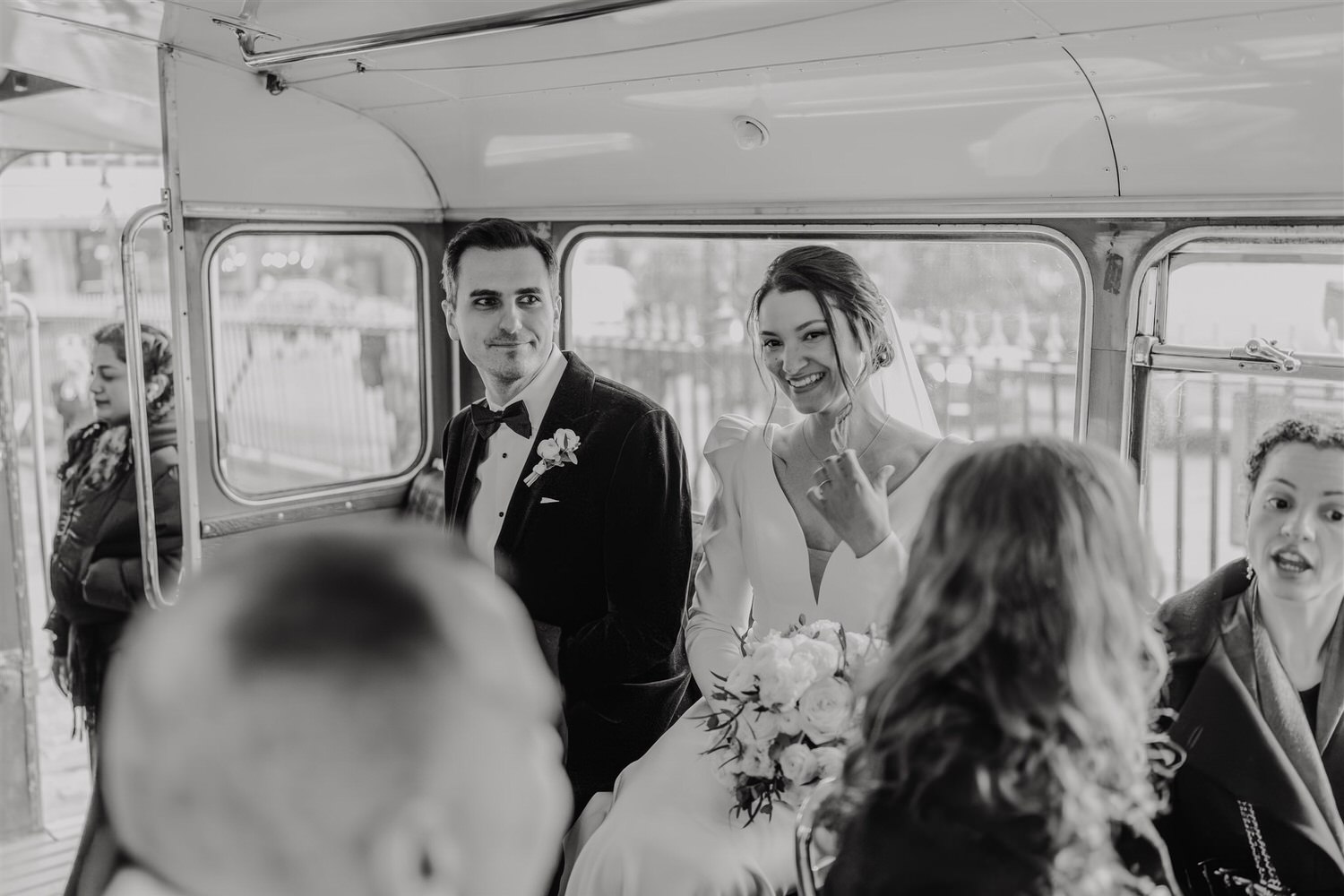 black and white photo of bride and groom on routemaster bus at winter wedding in london tower bridge