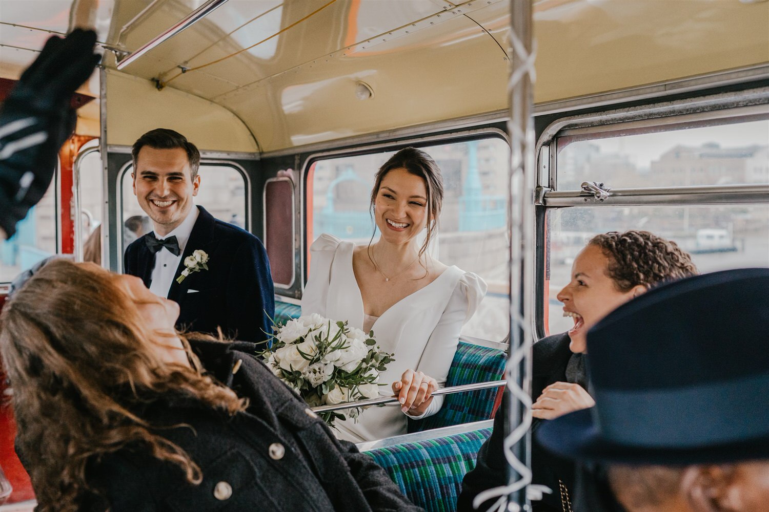 bride and groom on routemaster bus at winter wedding in london tower bridge