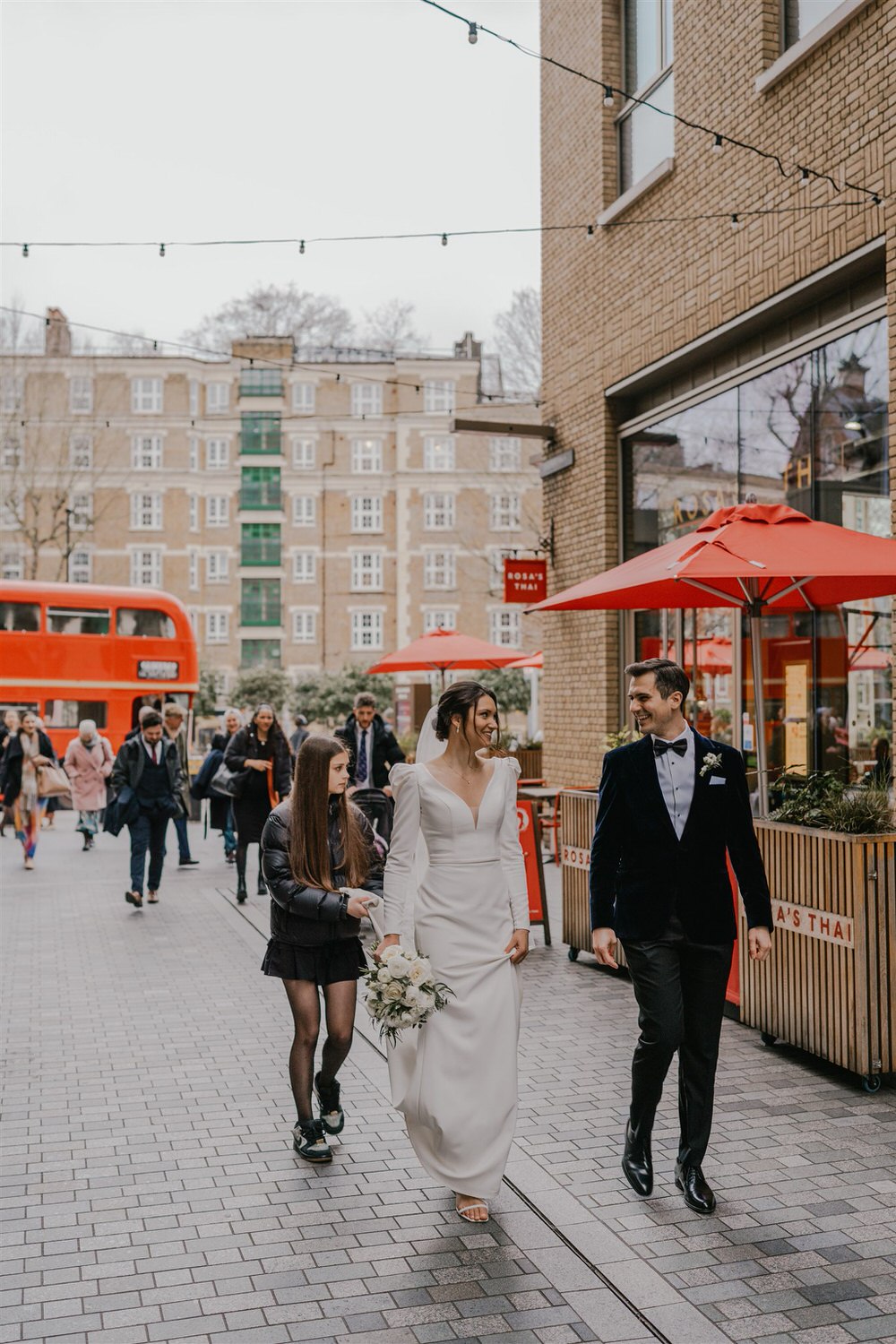 bride and groom walk to wedding reception at winter wedding in london tower bridge