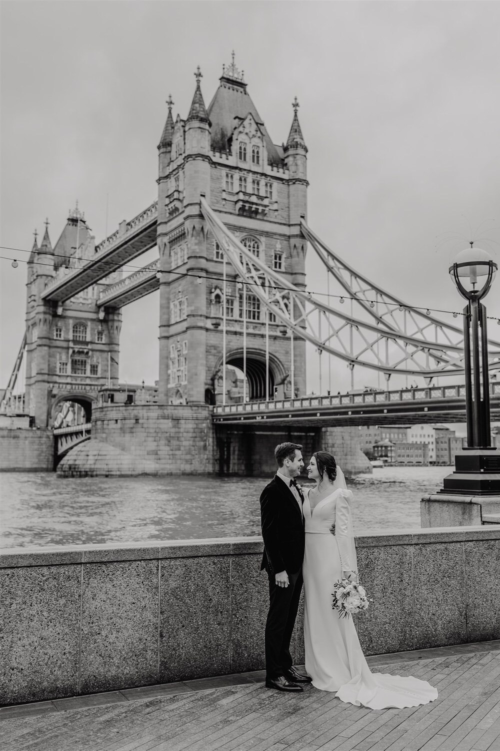 black and white bride and groom couple portraits with tower bridge in london winter wedding